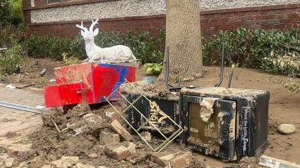 A pile of various rubbish items, mud, and rocks, leading into an article titled "Weather and Waste: Rethinking Small Business Support Following a Natural Disaster".