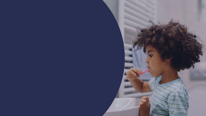 A child brushing their teeth at a window