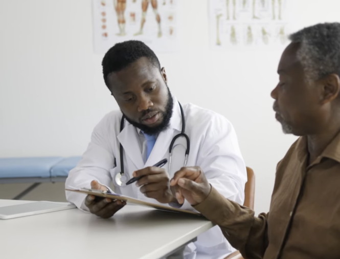 A doctor with a clipboard having a discussion with an elderly patient