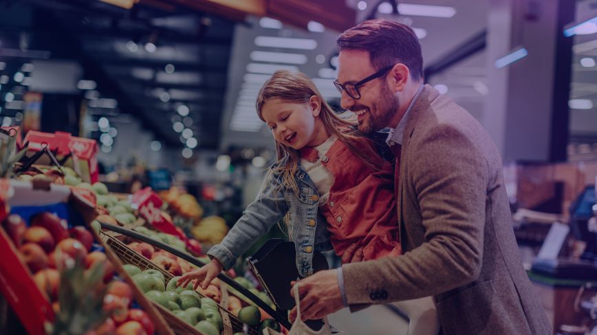 A dad and daughter shop for fresh produce