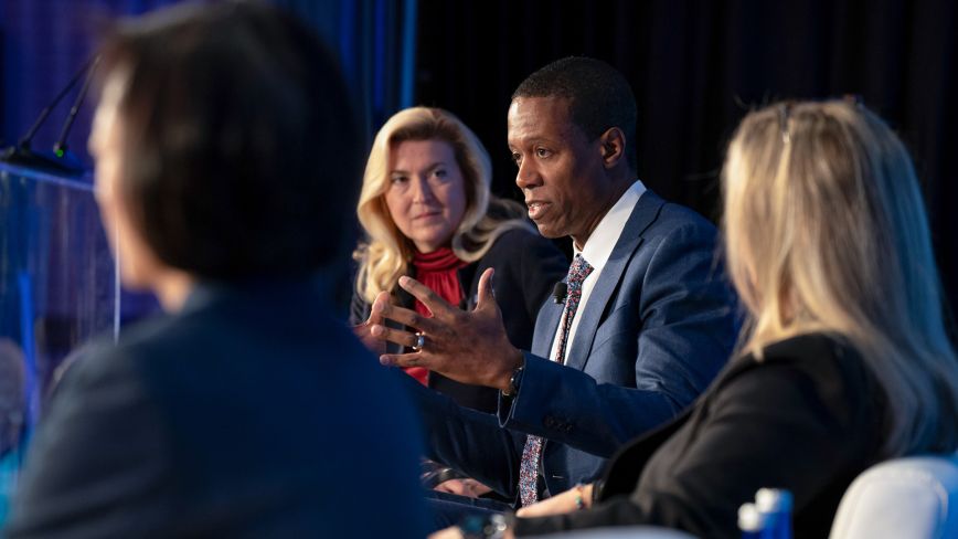 people in deep conversation on a public finance forum panel
